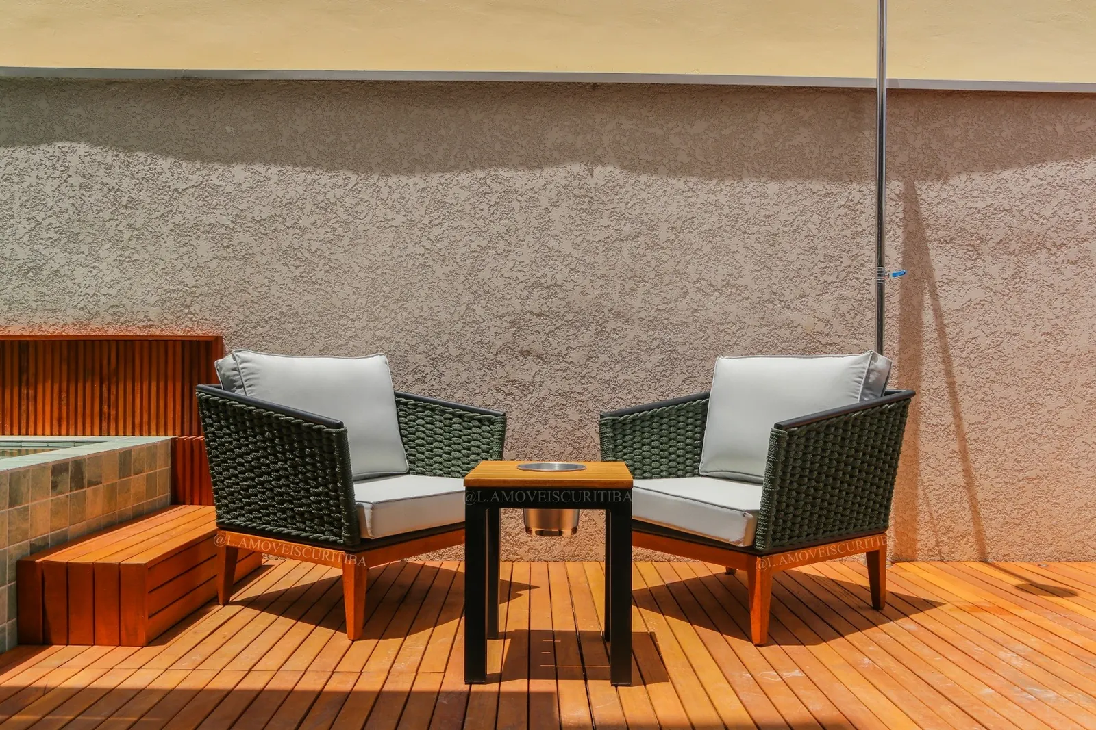 Par de poltronas em corda náutica verde com almofadas claras ao lado da hidromassagem