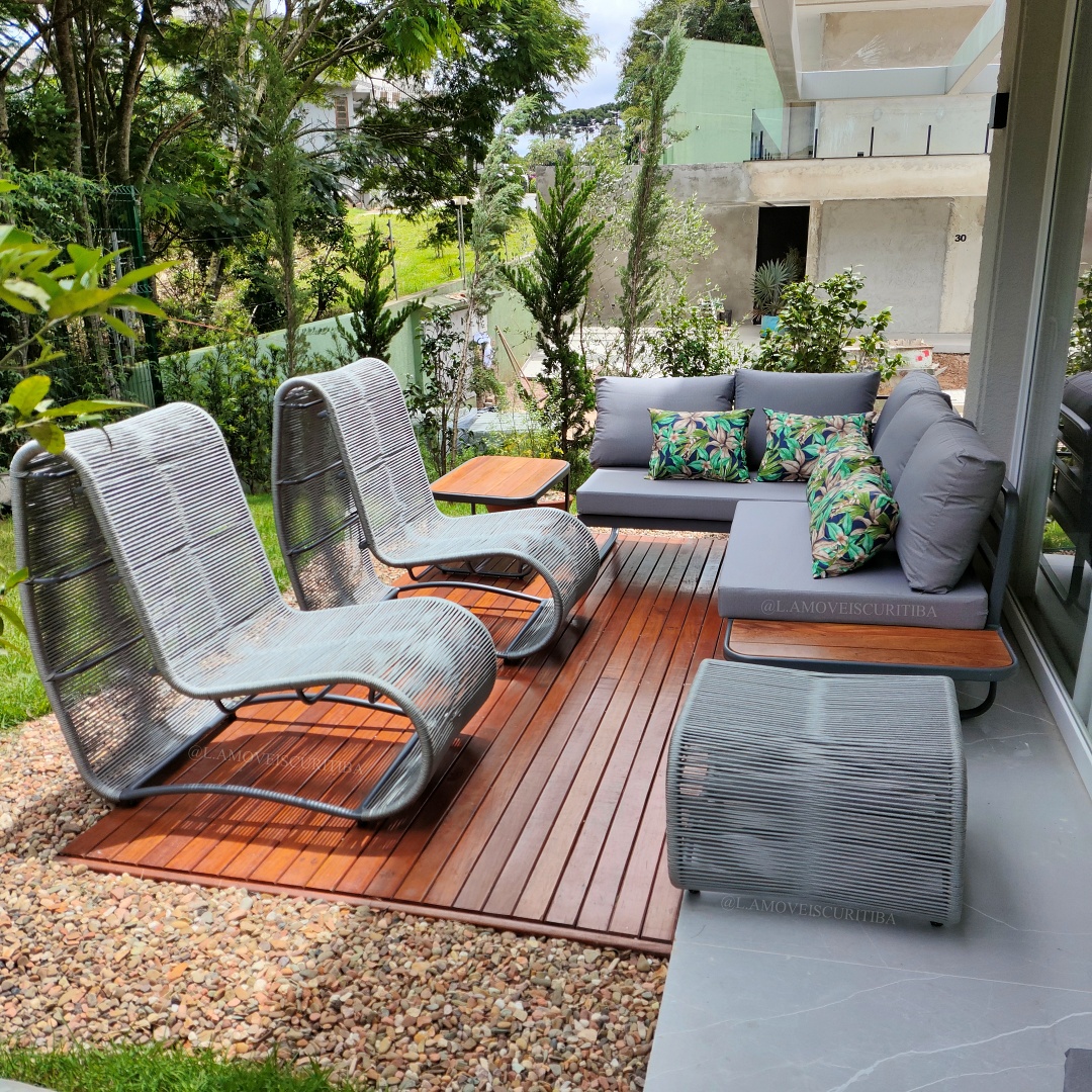 Poltronas outdoor em jardim com vegetação ao redor