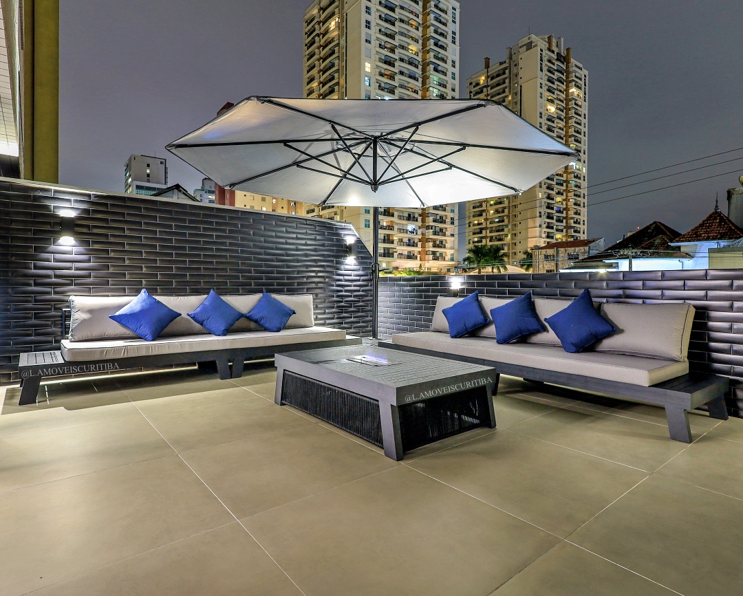 Rooftop iluminado à noite com lounge outdoor