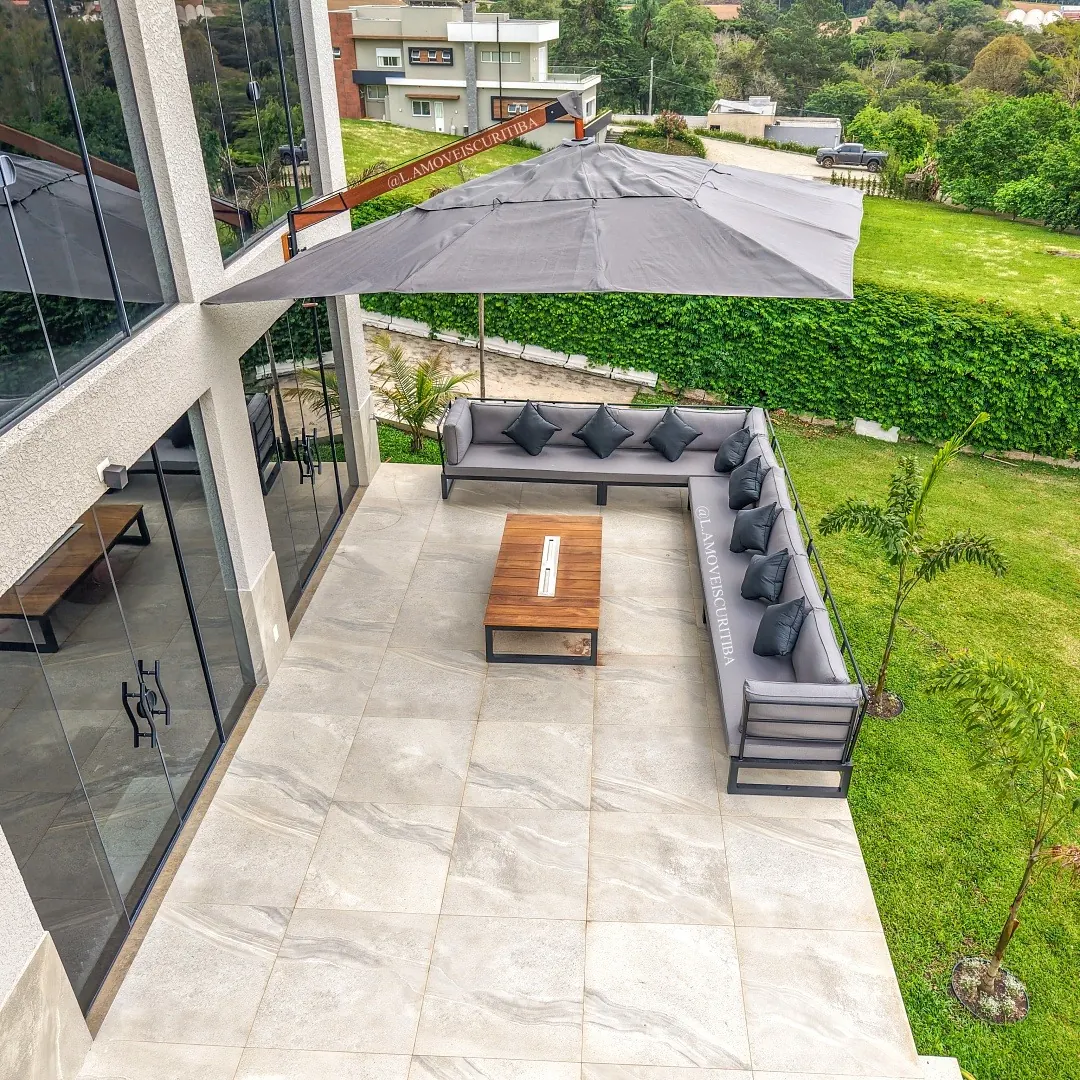 Vista aérea do terraço do salão de festas com sofá modular em L e mesa de centro em Cumaru
